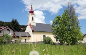 Kirche in Mitterbach, © weinfranz.at Kirche in Mitterbach mit rotem Turm und grünem Baum im Vordergrund.