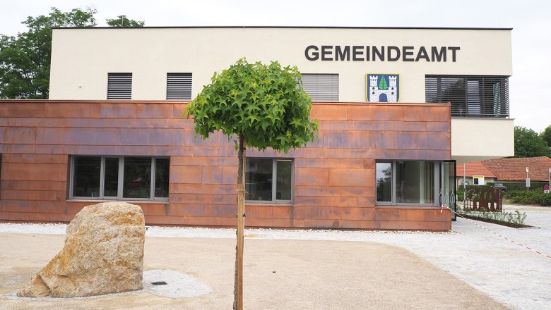 Rathaus Sieghartskirchen, © Marktgemeinde Sieghartskirchen Modernes Gebäude des Gemeindeamts Sieghartskirchen mit Baum und Stein im Vordergrund.