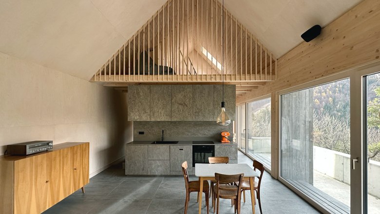 Offen Küche, © Meinrad Hofer Moderne offene Küche mit Holzelementen und großen Fenstern.