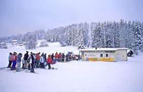 Aichbelberglifte Karlstift, © Waldviertel Tourismus, Reinhard Mandl Skifahrer stehen in einer Schlange vor einem Skilift in einer verschneiten Winterlandschaft.