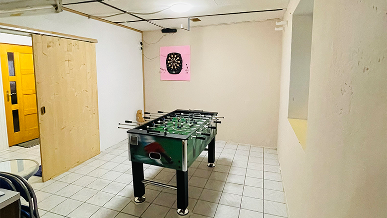 Spielzimmer, © Angelika Burger Ein Spielzimmer mit einem Tischkicker und einer Dartscheibe an der Wand.