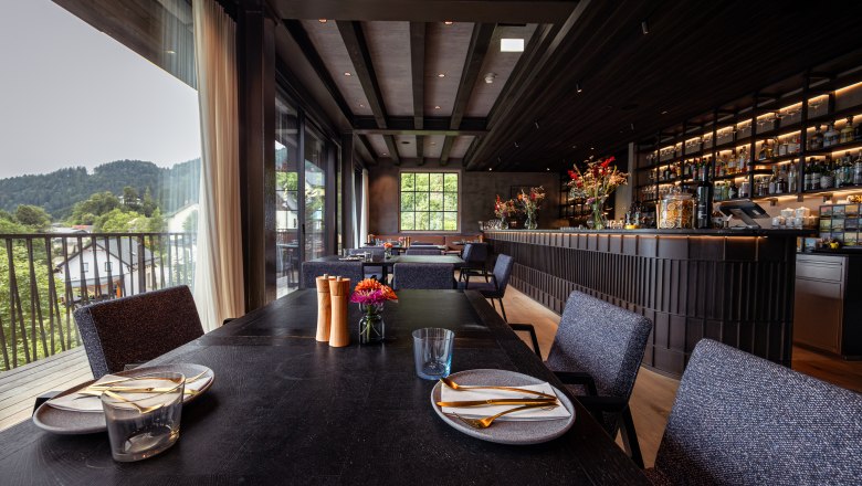 Refugium Lunz, © Niederösterreich Werbung / Maximilian Pawlikowsky Innenansicht eines modernen Restaurants mit gedecktem Tisch und Bar im Hintergrund.