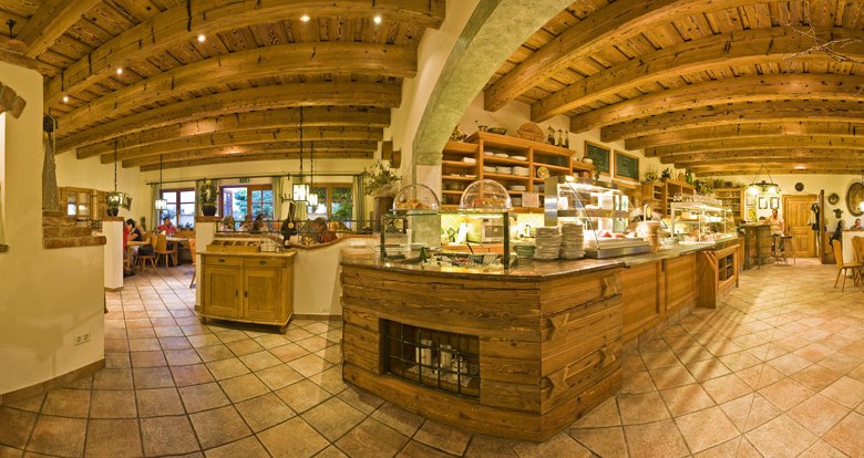 Heurigenlokal, © Weingut Aumann Innenansicht eines gemütlichen Heurigenlokals mit Holzbalkendecke und rustikaler Einrichtung.