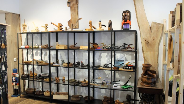 rundgang-1, © Johann Peham Regal mit Holzobjekten und Werkzeugen in einem Ausstellungsraum.