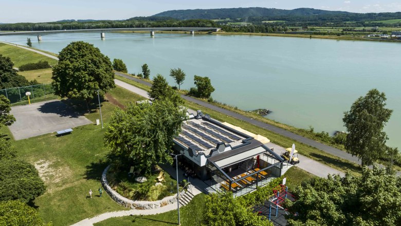 Bee Bar in Klein-Pöchlarn Luftaufnahme, © Robert Herbst Luftaufnahme der Bee Bar in Klein-Pöchlarn am Flussufer mit umliegender Landschaft.