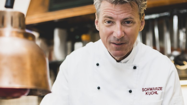 Wirt Andreas Macher, © Niederösterreich Werbung/David Schreiber Koch in weißer Uniform in einer Küche mit Kupferlampe.