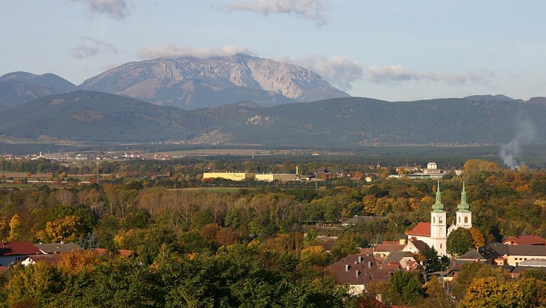 Schwarzau am Steinfeld, © Steindy, CC BY-SA 3.0 Panorama von Schwarzau am Steinfeld mit Kirche und Bergen im Hintergrund.