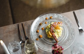 Internationale Einflüsse ergänzen heimische Kochlinie, © Niederösterreich Werbung/Michael Reidinger Elegantes Gericht mit Oktopus und Beilage auf gläsernem Teller serviert.