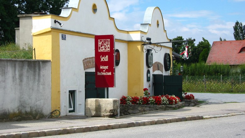 Seidl-Keller, © Fam. Seidl Weingut Seidl mit gelbem Gebäude und rotem Schild.