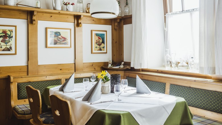 Stube mit Stammtisch, © Niederösterreich Werbung/David Schreiber Gemütliche Stube mit Holzmöbeln, gedecktem Tisch und Bildern an der Wand.