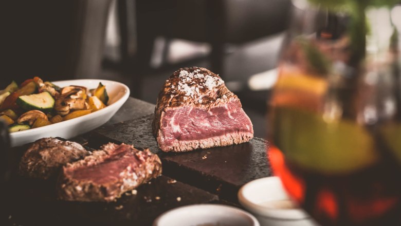 Steak auf heißem Stein, © Route 66 Fehr Ein saftiges Steak auf einem heißen Stein, begleitet von Gemüse und Soßen in Schälchen.