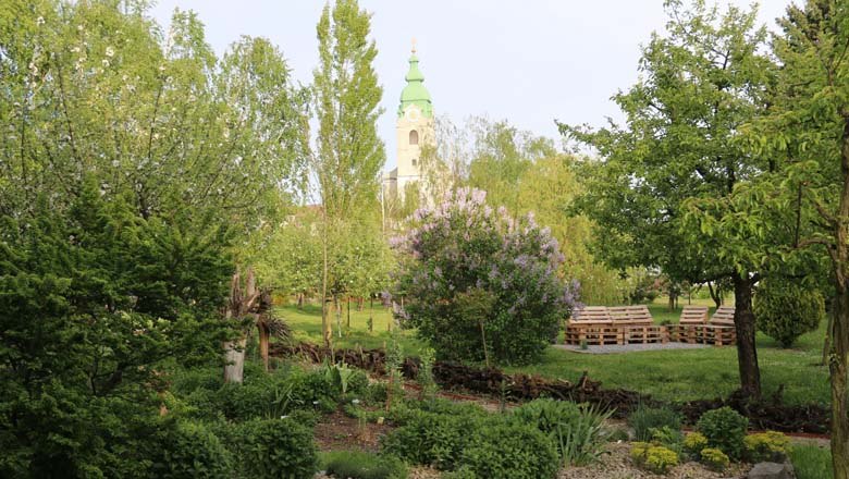 Angergärten Unterretzbach, © Wolfgang Gerzer Grüne Gartenlandschaft mit Kirchturm im Hintergrund.