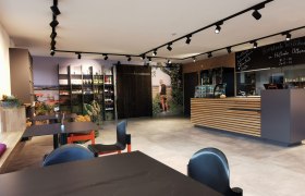 hofladen-klein, © Helmut Leonhartsberger Eingangsbereich mit Stühlen und einem Empfang aus Holz.