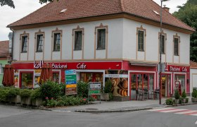 Fachgeschäft mit Café in Pitten, © Koll GmbH Ein zweistöckiges Gebäude mit einem Café und Bäckerei im Erdgeschoss in Pitten.