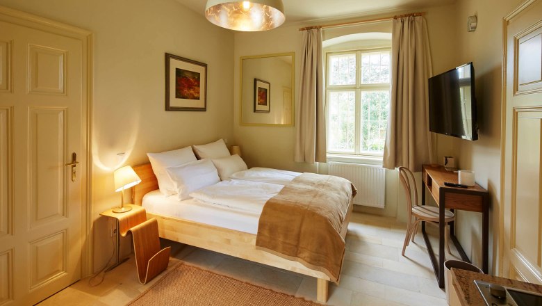 Apartment Steinfeld in der Villa Tranquillini, © Herbert Lehmann Gemütliches Schlafzimmer mit Doppelbett, Schreibtisch und großem Fenster.