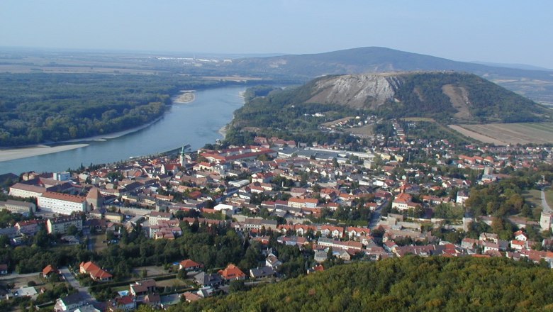 Blick vom Hexenberg, © Gästeinfobüro Hainbur/Donau Panoramablick auf eine Stadt mit Fluss und Hügeln im Hintergrund.