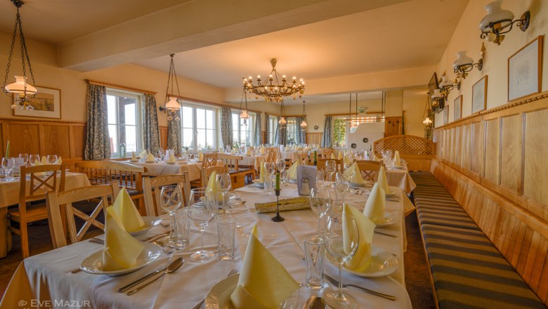 Restaurant, © Alpengasthof Enzian / Eve Mazur Elegantes Restaurant mit gedeckten Tischen und Kronleuchter.