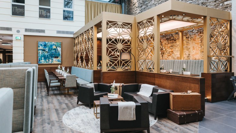 Café Wohnzimmer im EKZ Steiner Tor, © FMS Steinertor Gastronomie BetriebsgmbH Innenansicht eines stilvollen Cafés mit modernen Möbeln und dekorativen Wänden.