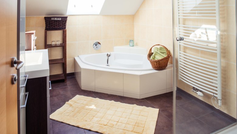 Badezimmer, © Bioweingut Jakob Modernes Badezimmer mit Badewanne, Handtuchhalter und Dachfenster.