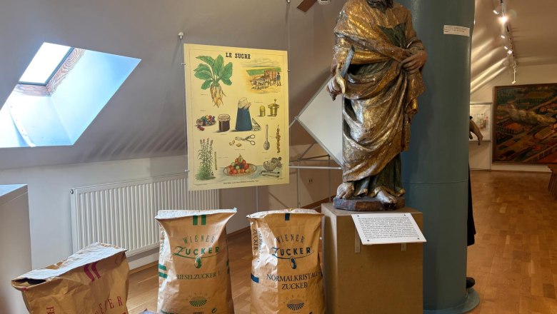 Österreichisches Zuckermuseum, © Stadtgemeinde Tulln Ausstellung im Zuckermuseum mit Statue, Zuckersäcken und Poster.