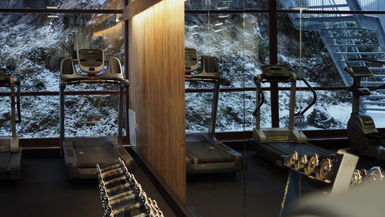 Fitnessraum im Sporthotel, © Sporthotel am Semmering Fitnessraum mit Laufbändern und Hanteln, Fenster mit Blick auf verschneite Landschaft.