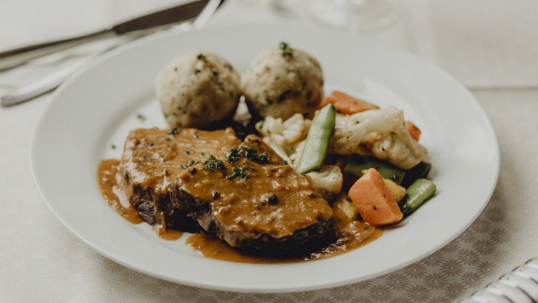 Alm-Ochensbraten, Speckrahmsafterl, Rosengemüse & Semmelknödel, © Niederösterreich Werbung/Sophie Menegaldo Ein Teller mit Ochsenbraten, Speckrahmsauce, Gemüse und Semmelknödeln.