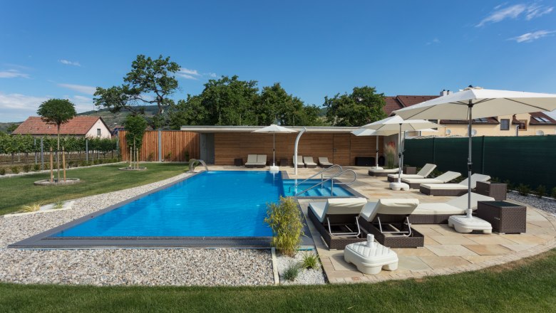 Außenpool mit Liegestühlen, © KASTNER NEW MEDIA - kastner.tv Moderner Außenpool mit Liegestühlen und Sonnenschirmen in einem gepflegten Garten.