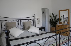 Schlafzimmer 1, © vera.s Schlafzimmer mit Metallbett, Kommode und Pflanze.