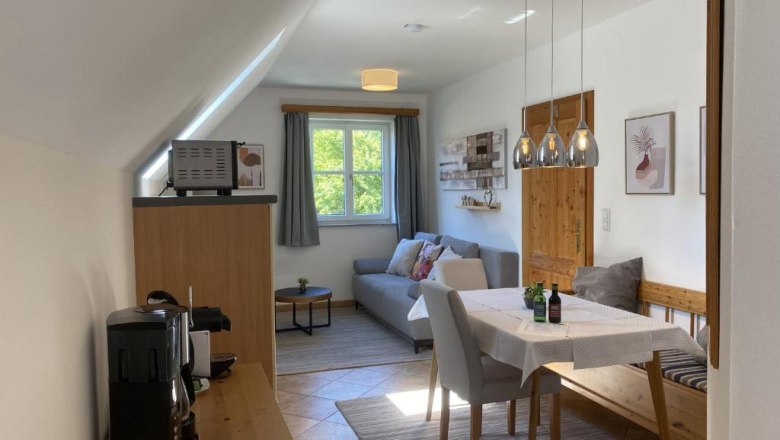 Landhaus Rossatz, © Familie Schlager Gemütliches Wohnzimmer mit Esstisch, Sofa und Küchenzeile in einem Landhausstil.