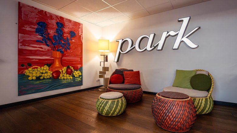 At the Park Hotel, © Niederösterreich Werbung / Maximilian Pawlikowsky Ein stilvoller Hotel-Loungebereich mit bunten Möbeln und einem großen Gemälde an der Wand.