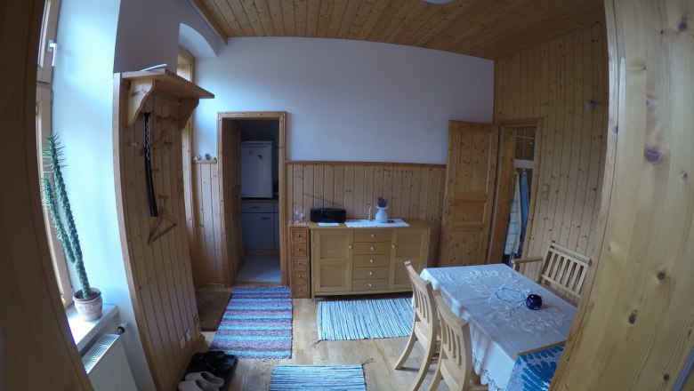 Esszimmer Ferienwohnung 2, © dmgrauszer Esszimmer in einer Ferienwohnung mit Holzwänden, Esstisch, Stühlen und Teppichen.