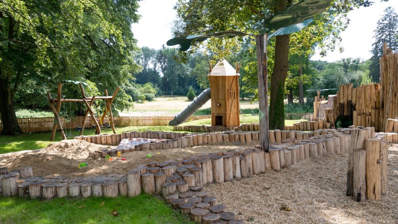 Schloss Eckartsau ÖBf-ArchivFrank Helmrich (84), © ÖBf-ArchivFrank Helmrich Spielplatz mit Holzspielgeräten und Rutsche im Freien.