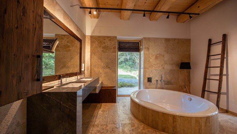 Ferienhaus am See, © Niederösterreich Werbung / Maximilian Pawlikowsky Modernes Badezimmer mit freistehender Badewanne, großem Spiegel und Holzbalkendecke.