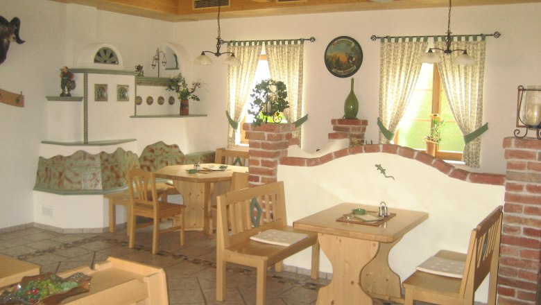 Heuriger Lahrnsteig, © Familie Lahrnsteig Gemütlicher Innenraum eines Heurigen mit Holzmöbeln und dekorativen Elementen.