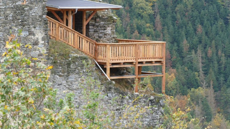 Burgruine Senftenberg 8, © Verein zur Erhaltung der Burgruine Senftenberg Holzplattform an einer Burgruine mit Wald im Hintergrund.