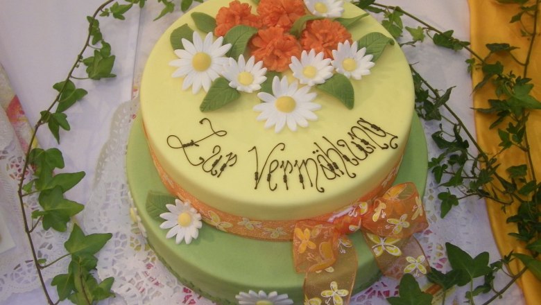 Tortenbäckerei, © Konditorei Köller Zweistöckige Torte mit Blumen und Schriftzug 'Zur Vermählung'.