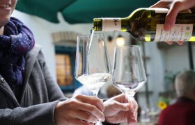 Verkostung, © Bio-Weinbau Killmeyer Wein wird in ein Glas gegossen, während eine Person es hält.