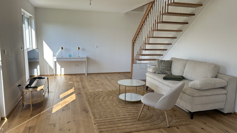 Feigenterrasse am Semmering, © Stupacher Modernes Wohnzimmer mit Holztreppe, Sofa, Sessel und Tisch.