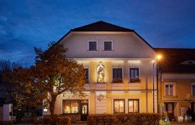 Gasthaus mit Wild aus eigener Jagd, © Niederösterreich Werbung/Andreas Hofer Gasthaus St. Florian bei Dämmerung mit beleuchteter Fassade und Statue.