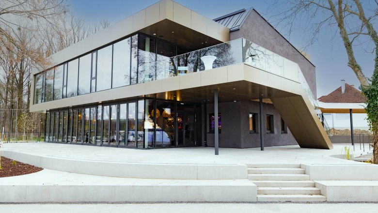 Außenansicht Mole Melk, © Mole Melk Moderne Gebäudeaußenansicht mit Glasfassade und Treppe.