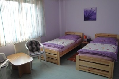 Pension Steindl, © Familie Steindl Ein einfach eingerichtetes Zimmer mit zwei Einzelbetten, einem kleinen Tisch und zwei Stühlen.