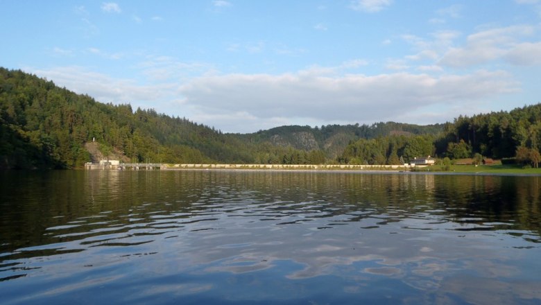 Stausee Thurnberg, © OEFG 1880 Stausee Thurnberg mit bewaldeten Hügeln und Damm im Hintergrund.