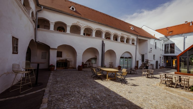 vierzigerhof, © Niederösterreich Werbung / Maximilian Pawlikowsky Innenhof eines historischen Gebäudes mit Arkaden und Sitzgelegenheiten.