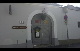 Netzl`s Heuriger, © Donau Niederösterreich Eingang zu Netzl's Heuriger mit grauer Tür und Schild.