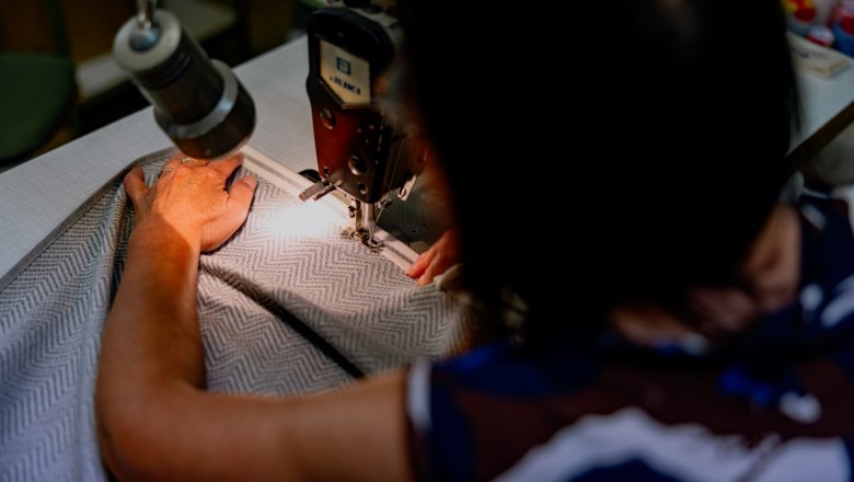 Framsohn Frottier, © Waldviertel Tourismus, Matthias Streibel Person näht Stoff mit Nähmaschine.