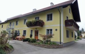 Haus Heimberger, © Familie Heimberger Gelbes zweistöckiges Haus mit Balkon und Garten.