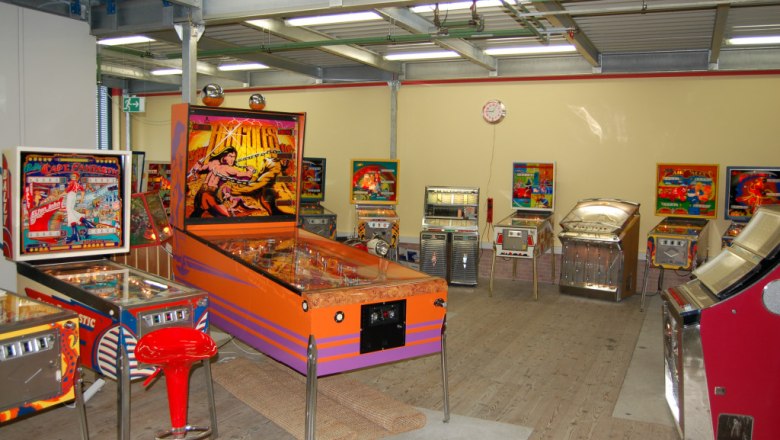 Pindigiland, © Pindigiland Raum mit mehreren Flipperautomaten und Jukeboxen.