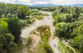 Leitha-Ursprung in Lanzenkirchen, © Wiener Alpen, Martin Fülöp Luftaufnahme des Leitha-Ursprungs in Lanzenkirchen mit Fluss und grüner Vegetation.