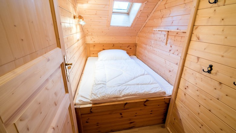 Wohnung "Sonnenschein" Kinderzimmer, © Familie Morgenbesser Kleines Kinderzimmer mit Holzverkleidung, Einzelbett und Dachfenster.