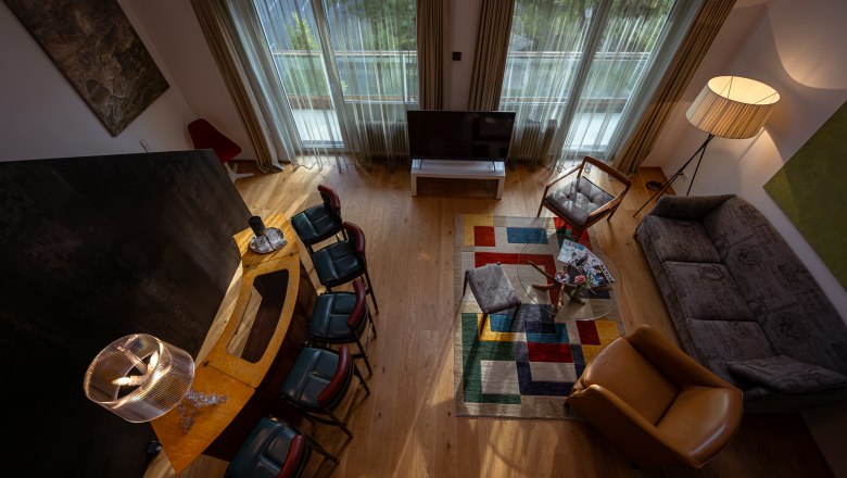 At the Park Hotel, © Niederösterreich Werbung / Maximilian Pawlikowsky Wohnzimmer mit moderner Einrichtung, buntem Teppich und großen Fenstern.